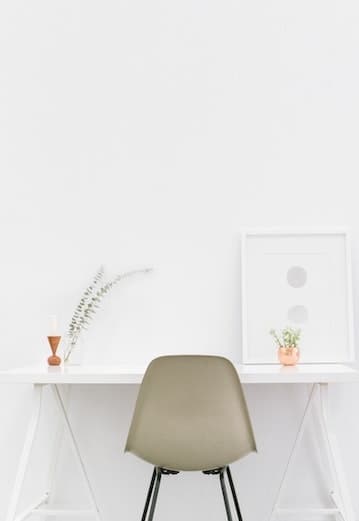 Photo d'une chaise beige vintage d'occasion devant un hureau blanc.