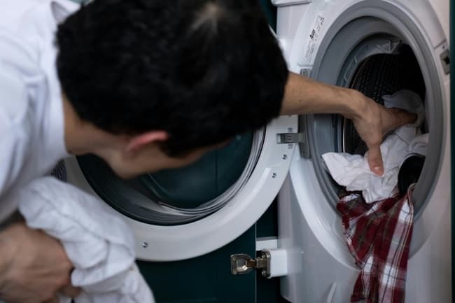 Un home vide le sèche-linge