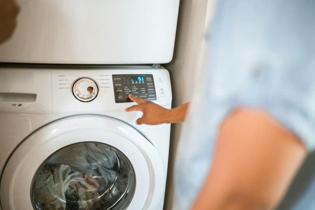 une personne allume un sèche-linge