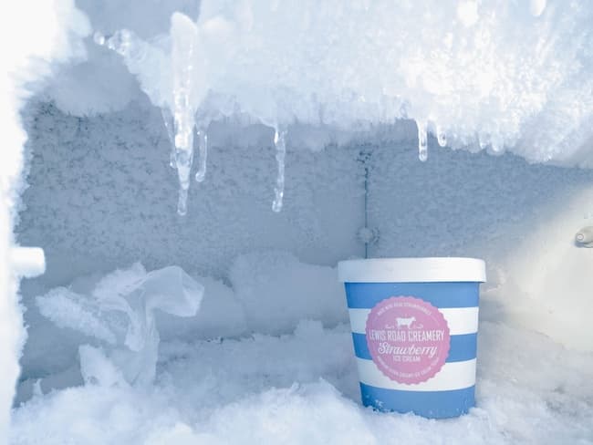 Strawberry ice cream bottle inside container covered in ice